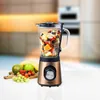 A copper-colored blender filled with fruit and ice sits on a white countertop, with a cutting board of fresh fruit in the foreground. Voir les images du produit