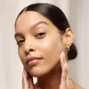 A woman applying cream to her face. Produktbild-Vorschau