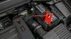 A car battery jump starter is connected to a car battery under the hood of a car. Náhled obrázku produktu