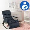 A dark gray rocking chair is placed in a nursery setting, next to a white crib and a dresser. A pink rug is on the floor. A blue circular icon with a white silhouette of a person breastfeeding is in the upper right corner. Náhled obrázku produktu