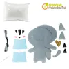 A flat lay of a sewing kit for a stuffed animal, including felt pieces, thread, needle, and stuffing. Produktbild-Vorschau