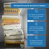 A stack of folded bedding and a bed frame with a mattress. Produktbild-Vorschau