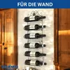 A black metal wine rack mounted on a wall, holding six bottles of wine. The rack is ornate with decorative scrollwork at the top. The background shows a wooden cabinet and a textured wall. Produktbild-Vorschau