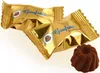 Two golden-wrapped chocolates and one unwrapped chocolate are displayed against a white background. Náhľad obrázku produktu