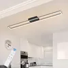 A modern kitchen with a sleek ceiling light and a remote control in the foreground. Voir les images du produit