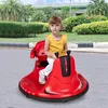 A young girl is sitting on a red ride-on car in an outdoor setting with trees and bushes in the background. Náhľad obrázku produktu