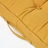 A close-up view of a yellow cushion, showing its texture and stitching. Náhled obrázku produktu