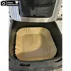 A close-up view of an air fryer basket lined with parchment paper. Produktbild-Vorschau