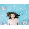 A young girl lying on a blue background with mermaid-themed party decorations. Produktbild-Vorschau