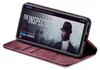 A smartphone in a burgundy flip case is displayed at an angle, showing the phone's screen which displays a movie poster for 'The Inspector'. Produktbild-Vorschau