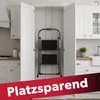 A compact step stool is stored inside a kitchen cabinet. Produktbild-Vorschau