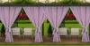 Outdoor dining area with purple curtains, table, and chairs.