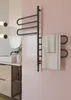 A modern bathroom with a sink, vanity, and a black electric towel warmer with towels hanging on it. Náhľad obrázku produktu