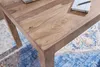 A close-up view of a wooden table with a rug underneath. Anteprima dell’immagine prodotto