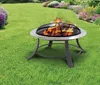 A fire pit with flames burning in a grassy backyard with flowers in the background. Produktbild-Vorschau