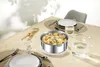 A table setting with a pot of pasta and vegetables, plates, glasses, and cutlery. Produktbild-Vorschau