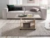 A living room scene featuring a couch, coffee table, and rug. Produktbild-Vorschau