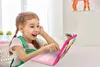 A young girl is happily using a pink laptop. Produktbild-Vorschau