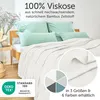 A neatly made bed with light-colored bedding and mint green pillows, suggesting a comfortable and cool sleeping environment. Anteprima dell’immagine prodotto