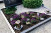 A grave site decorated with gravel, plants, and a lantern. Produktbild-Vorschau