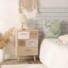A bedside table with drawers next to a bed in a bedroom setting. Náhled obrázku produktu
