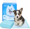 A puppy sits next to a package of pet training pads. Produktbild-Vorschau
