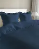 A bed with navy blue bedding and pillows. Anteprima dell’immagine prodotto