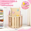 A children's indoor climbing structure with various accessories, shown in a room setting with a toy shelf in the background. Voir les images du produit