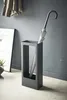A modern, minimalist entryway scene with a Yamazaki umbrella stand holding an umbrella, next to a framed poster and a plant. Produktbild-Vorschau