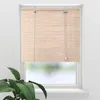 A bamboo roller blind is shown hanging in a window, with a plant in the foreground. Náhled obrázku produktu