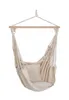 A beige fabric hammock chair with a pillow, suspended from a wooden bar by ropes. Produktbild-Vorschau