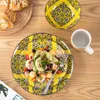 A table setting with a salad on a decorative plate, croissants, and a mug. Náhled obrázku produktu