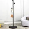 A coat rack with a handbag hanging on it, placed in a room with furniture. Produktbild-Vorschau