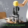 A person is shown inserting a piece of pineapple into a juicer. The juicer is on a table with two collection cups and a wooden cutting board. Text overlays highlight a feature of the juicer. Produktbild-Vorschau
