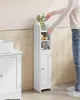 A person is placing a green plant in a vase on top of a tall, slim white storage cabinet in a bathroom. Náhled obrázku produktu