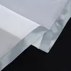 A close-up view of the edge of a white sheer curtain with a satin trim. Produktbild-Vorschau