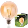 A large, amber-colored globe-shaped LED light bulb is shown next to its packaging. Produktbild-Vorschau