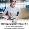 A woman is working on a laptop with an external hard drive connected. Produktbild-Vorschau