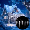 A snow-covered house decorated with white LED icicle lights at night. Anteprima dell’immagine prodotto