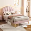 A pink upholstered bed with a shell-shaped headboard in a bedroom setting. Produktbild-Vorschau