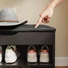 Hand drückt auf gepolsterte Sitzfläche der SoBuy Schuhbank FSR25-SCH mit Schuhen im Regal Produktbild-Vorschau