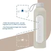 A glass water bottle with a silicone sleeve, shown with instructional graphics about drinking times and daily goals. Voir les images du produit