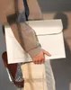 A person is holding a light-colored laptop/document slip. Anteprima dell’immagine prodotto
