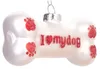 A white bone-shaped Christmas ornament with red glitter paw prints and the text "I love my dog" written in red glitter. Náhled obrázku produktu