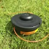 A trimmer head sits on grass. Produktbild-Vorschau