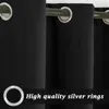 Close-up of black outdoor curtains with silver grommets. Voir les images du produit