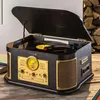 A Technaxx TX-103 multifunctional record player is shown on a wooden surface, with a stack of firewood in the background. Produktbild-Vorschau