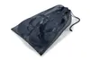 A pair of black flip-flops inside a black mesh drawstring bag. Produktbild-Vorschau