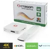 A white Octagon Spirit White 4K UHD Android TV Box and its remote are displayed next to its packaging. Produktbild-Vorschau