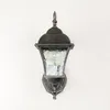 A vintage-style outdoor wall lamp mounted on a white textured wall. Produktbild-Vorschau